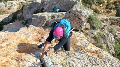 Eine Frau klettert entlang der Masua-Klippe