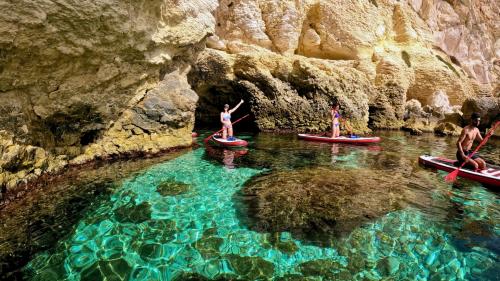 Gruppe junger Leute auf SUP in Cagliari