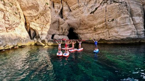 Gruppe junger Leute auf SUP in Cagliari