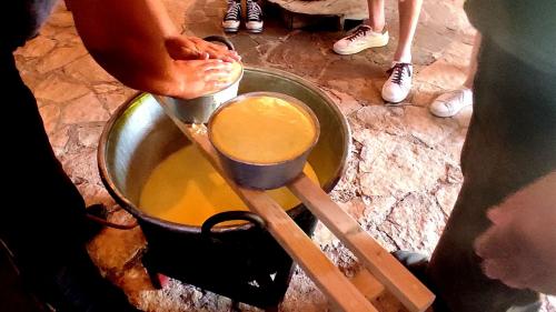 Preparazione del formaggio e della ricotta durante esperienza guidata in un'azienda nel nord ovest Sardegna