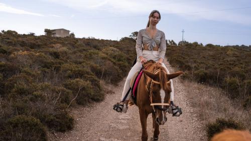 Mädchen reitet auf einem Pferd in der Gegend von Castelsardo