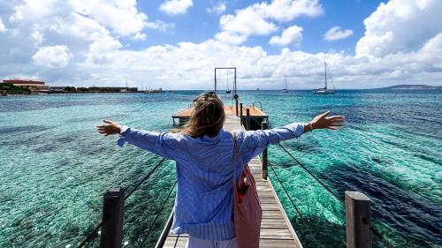 Girl spreads her arms wide in Cala Reale