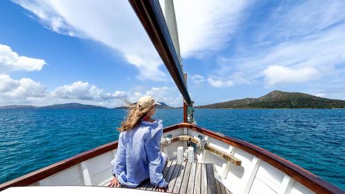 Une fille regarde l'horizon à la proue dans le golfe de l'Asinara