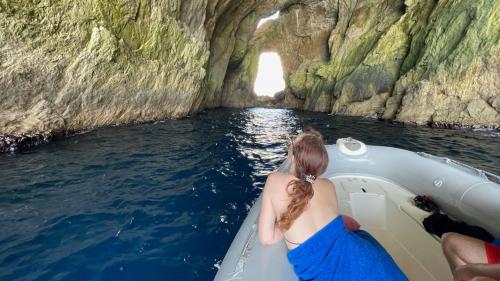 Una niña admira el interior de una cueva durante una excursión de snorkel en Alghero