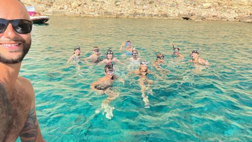 Randonneurs faisant de la plongée en apnée dans la mer à Porto Conte