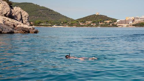 Une jeune fille fait de la plongée avec masque et tuba dans le parc de Porto Conte à Alghero