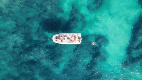 Halt des Beibootes zum Schnorcheln im blauen Wasser des Porto Conte Parks