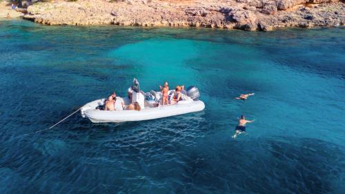 Inflatable boat stop for snorkeling activity among the coasts of Porto Conte Park