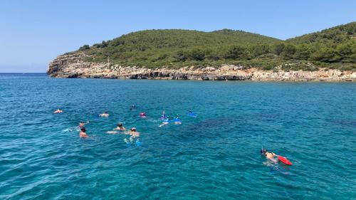 Hikers swim in the sea of Alghero